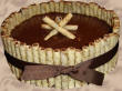 Simple cake with poured icing surrounded by candy rolls