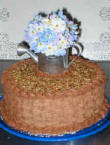 A bouquet of flowers perched in a watering canister.